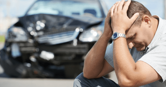 Man with his head in his hands after a car accident