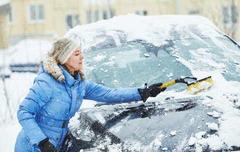 woman cleaning snow off her car