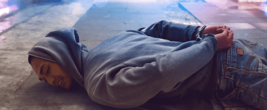 Man laying on his stomach with his hands behind his back