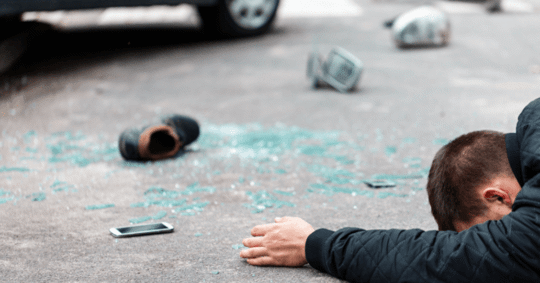 Man laying face down after a car accident